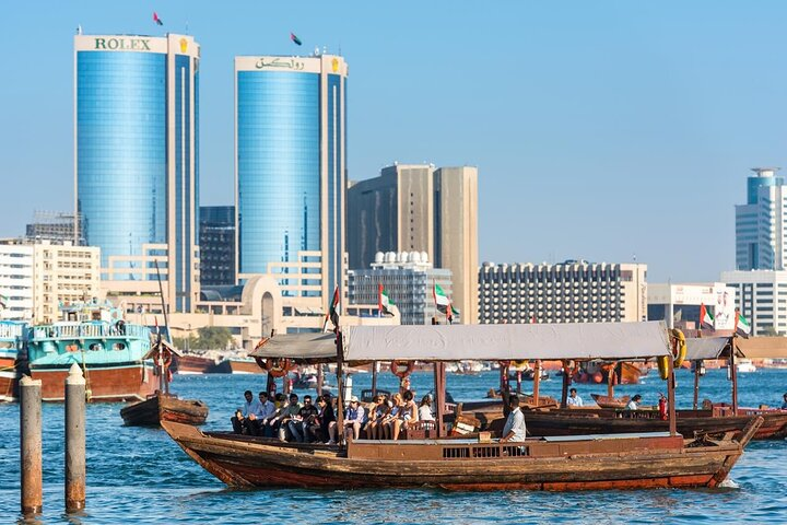 Experience the charm of Old Town Dubai as traditional abra boats glide across Dubai Creek intertwined with a stunning skyline that reflects the city's rich heritage and modern flair.